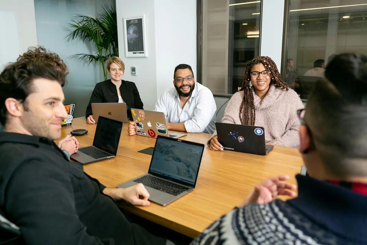 A manager leading a small team discussion around a table